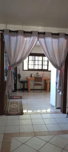 ein Wohnzimmer mit einem Vorhang und einem Tisch in der Unterkunft Hostel de Gaia in Santa Cruz do Sul