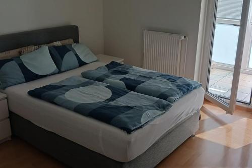 a bed with a blue comforter in a bedroom at barrierefreie Ferienwohnung am Lübecker Hof in Stockelsdorf