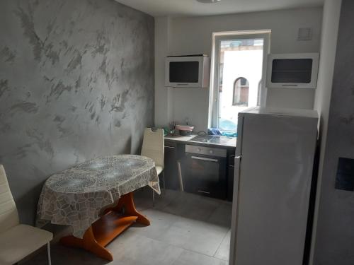 a small kitchen with a table and a refrigerator at Noclegi Pokoje Do Wynajęcia in Ożarów