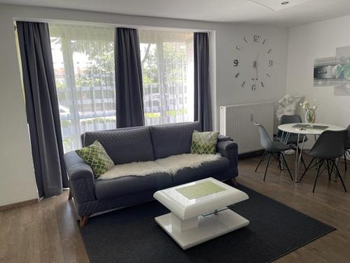 sala de estar con sofá, mesa y reloj en Bürgemeister Apartment en Augsburg