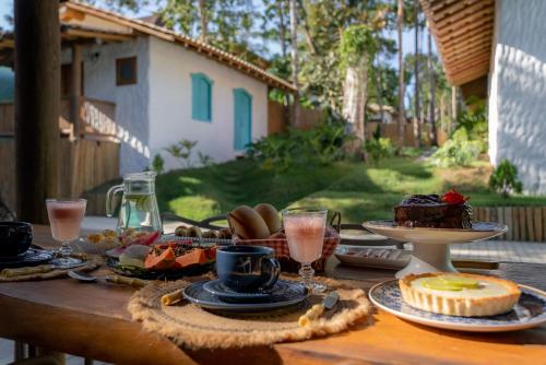 a wooden table with food and drinks on it at Villa Mediterrâneo Trancoso in Trancoso
