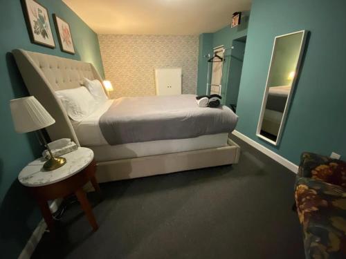 een hotelkamer met een bed en een spiegel bij Jasmine in CWE in Tower Grove