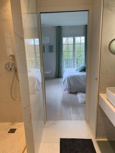 a bathroom with a glass door leading to a bedroom at Parenthèse Buc'olique in Buc