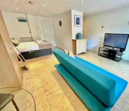 a living room with a blue couch and a bed at Cambridge City Centre Studio, Sleeps 3 in Cambridge