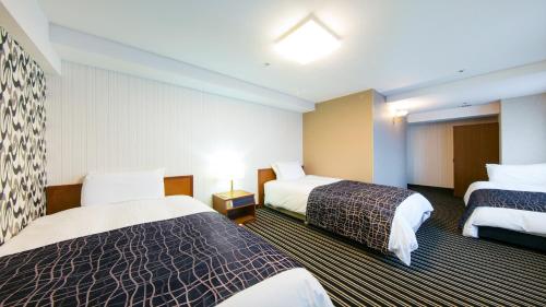 una habitación de hotel con 2 camas y una lámpara en APA Hotel Osaka-Tanimachi, en Osaka