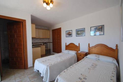 1 Schlafzimmer mit 2 Betten und einer Küche in der Unterkunft Villa Cumbre del Sol in Cumbre del Sol
