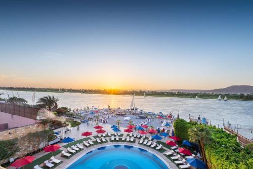 vista su una piscina con ombrelloni e un bacino d'acqua di Sonesta St. George Hotel - Convention Center a Luxor