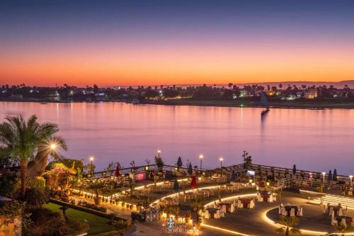 uitzicht op een stad 's nachts met het water bij Sonesta St. George Hotel - Convention Center in Luxor