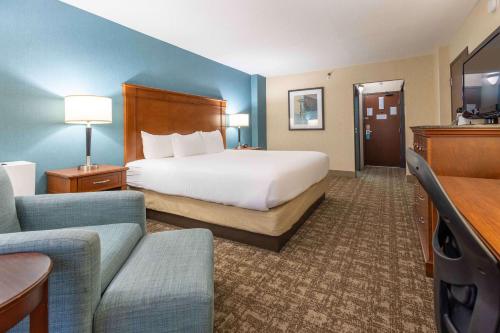 um grande quarto de hotel com uma cama e um sofá em Pear Tree Inn St. Louis Near Union Station em Saint Louis