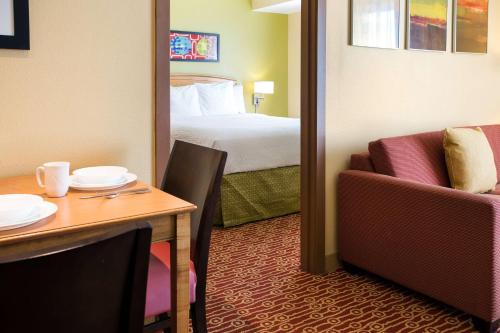 um quarto de hotel com uma cama e uma mesa e um quarto em Sonesta Simply Suites Phoenix Scottsdale em Scottsdale