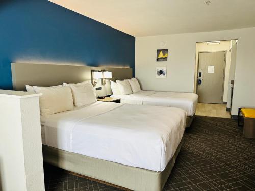 Comfort Suites Denver North - Westminster في وستمنستر: غرفه فندقيه سريرين وجدار ازرق