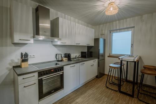 帕紹的住宿－Passaus Motto Appartements! Solo - Pärchen - Familien - Gruppen，厨房配有白色橱柜和炉灶烤箱。