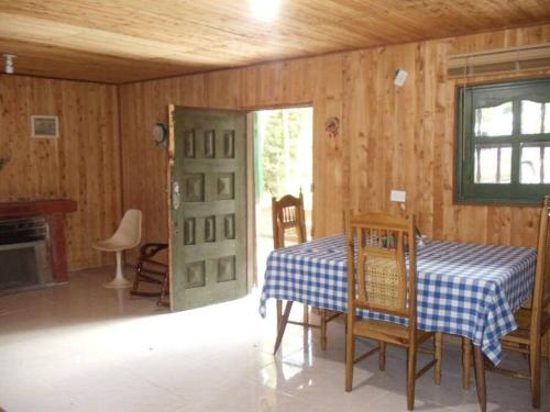 a dining room with a table and a green door at Finca Cottage Guarne, nearby Arvi and Santa Elena in Guarne