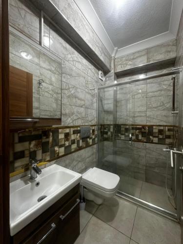 y baño con aseo, lavabo y ducha. en Ada apart motel, en Marmara