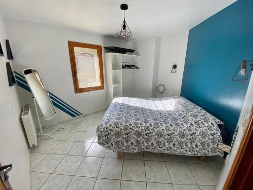 Un dormitorio con una cama y una pared azul. en Villa Coccinella, en Les Omergues