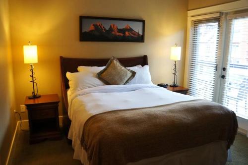 a bedroom with a large bed with two lamps at Gracie's Place in Canmore