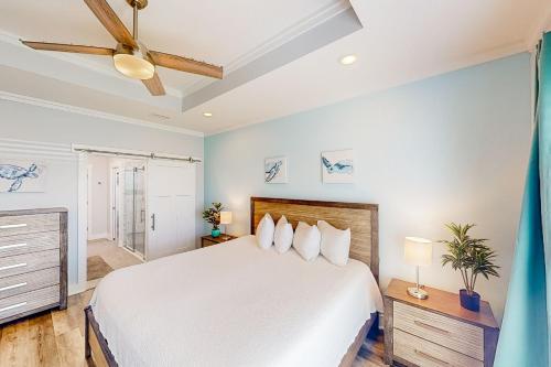 ein Schlafzimmer mit einem Bett und einem Deckenventilator in der Unterkunft Turtle Beach Retreat in Panama City Beach