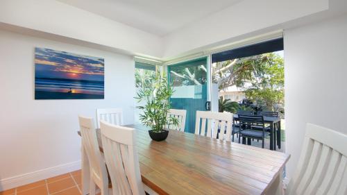 a dining room with a wooden table and chairs at Riverview Apartment 1 Block 1 in Iluka