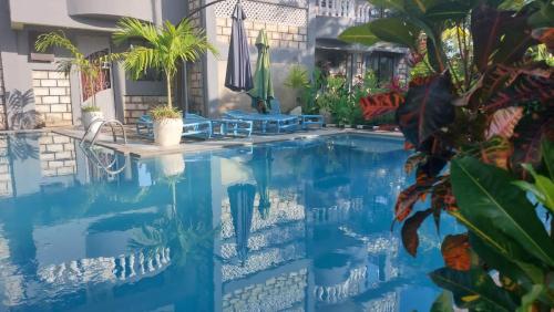 a swimming pool with blue water and plants at The Costal Sunny Daze,076 8976 732 in Mombasa