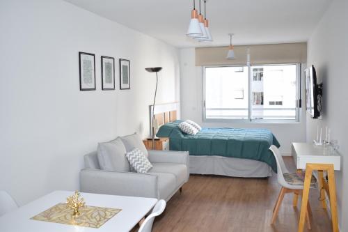 sala de estar con cama y sofá en Hermoso apartamento a 150 metros de la rambla en Montevideo