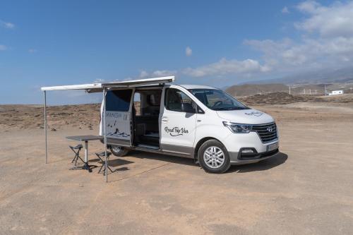 a white van with a tent and a table at Macaronesia Campervan in Costa Del Silencio