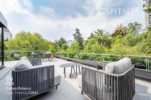 a patio with chairs and tables on a balcony at Capitalia - Luxury Apartments - Polanco - Alejandro Dumas in Mexico City