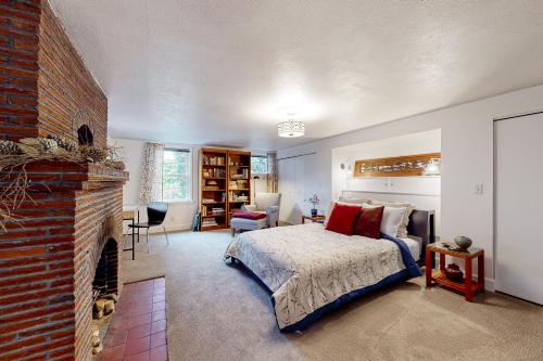 a bedroom with a bed and a brick fireplace at Multnomah Village Hideaway in Portland