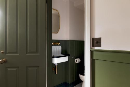a bathroom with a green door and a toilet at The Penn in Windermere