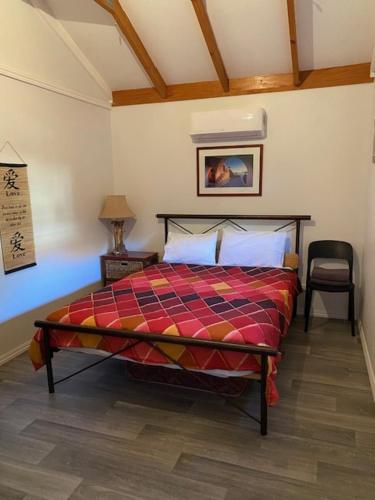 a bedroom with a bed and a chair in a room at Dongara Breeze Inn in Dongara