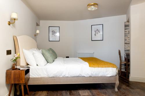 a bedroom with a bed with white sheets and pillows at The Penn in Windermere