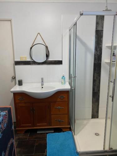 W łazience znajduje się umywalka oraz prysznic z lustrem. w obiekcie Dongara Breeze Inn w mieście Dongara