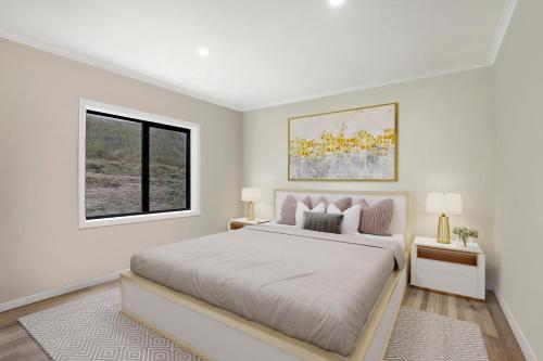 a white bedroom with a large bed and a window at Otway coastal villas in Princetown