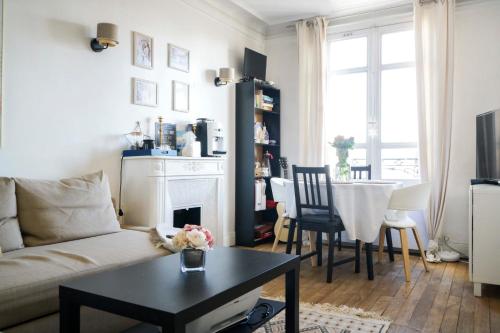 a living room with a couch and a table at Cozy love nest near the Eifel Tower in Paris