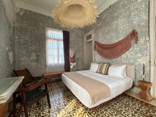 a bedroom with a bed and a desk and a piano at Historic House Hotel boutique in Mérida