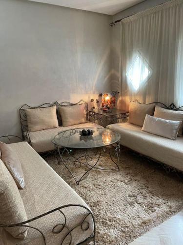 Sala de estar con 2 sofás y mesa en Authentic moroccan apartment, en Rabat