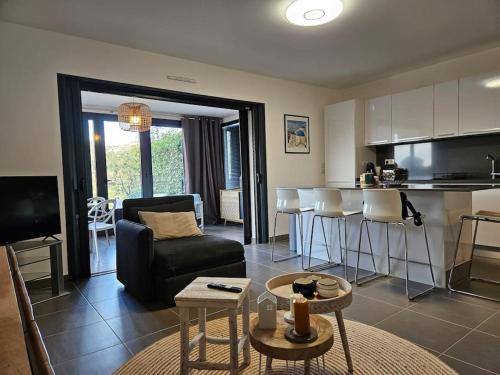 un salon avec un canapé noir et une cuisine dans l'établissement Suite Mare Vista by Monarca, à Saint-Florent