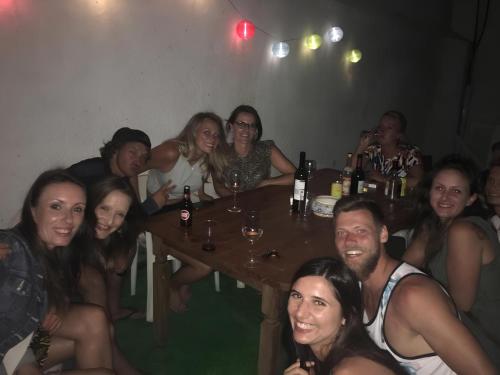 a group of people sitting at a table with drinks at Suntrap Hostel in Lagos