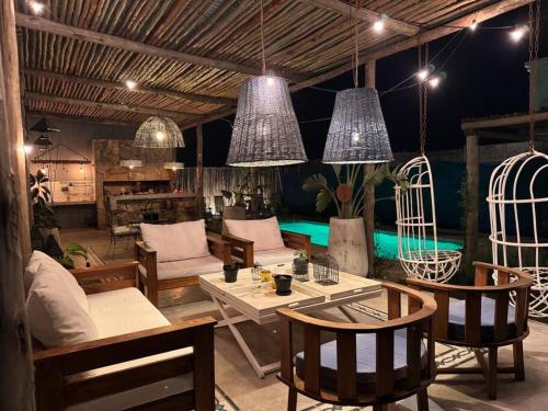 un soggiorno con tavoli, sedie e luci a ciondolo di El Descanso! a Concordia