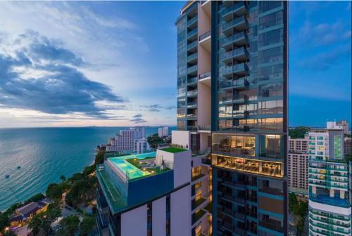 an aerial view of a tall building next to the ocean at Pratamnak apartment Andromeda complex near beach in Pattaya South