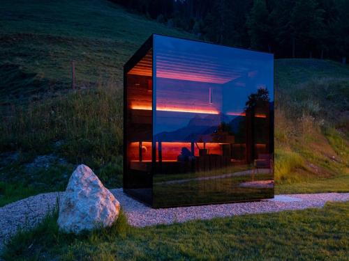a glass house in a field with a mirror at Mountain Hide-Away in Altbach