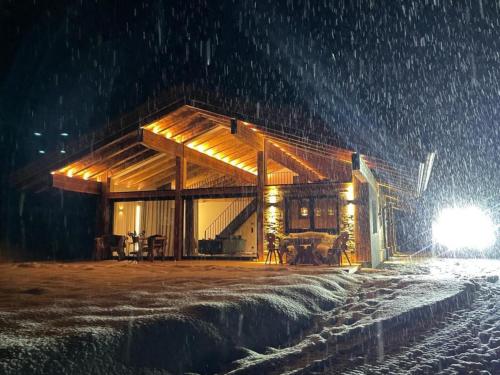 a wooden building in the snow at night at Mountain Hide-Away in Altbach