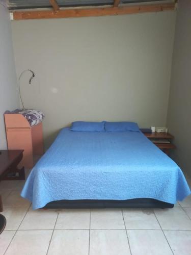 a bed with a blue bedspread in a bedroom at Tanganani guest house in Doornrandjies