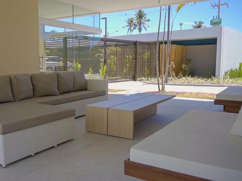 un soggiorno con divano e tavolo di Muro Alto-Porto de Galinhas Flat Makia 104D a Ipojuca