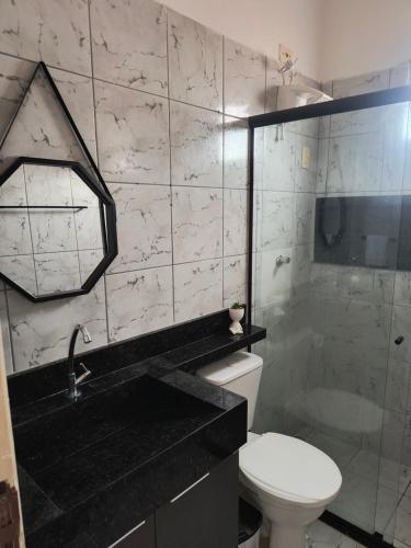 La salle de bains est pourvue de toilettes, d'un lavabo et d'une douche. dans l'établissement Minha casa fora de casa, à João Pessoa