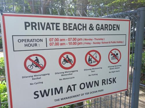 a sign that reads private beach and garden swim at own risk at Sunset View 969 PD Waterfront in Port Dickson