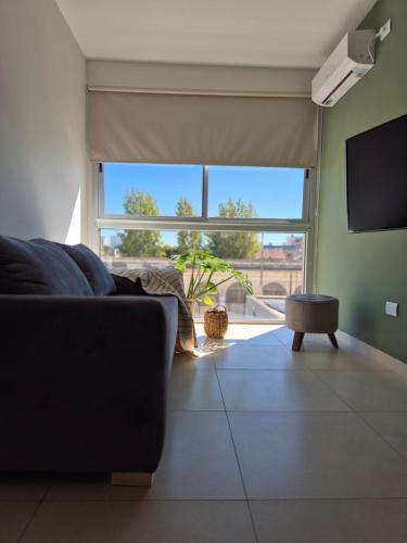 ein Wohnzimmer mit einem Sofa und einem großen Fenster in der Unterkunft BHIaparts-Roca con COCHERA in Bahía Blanca