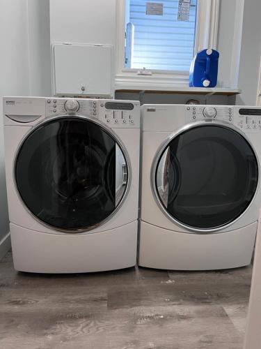 two washing machines are sitting next to each other at Calgary Mountain Elegant Suite close LRT&UC& Free Parking in Calgary