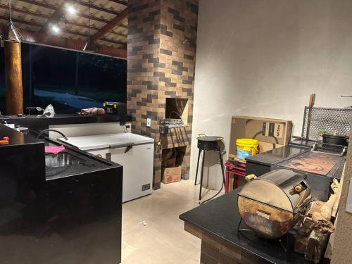 cocina con fogones y fregadero en una habitación en Chácara Paineiras, en Corumbaíba