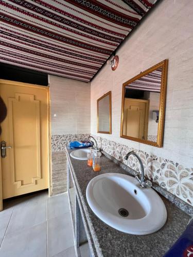 a bathroom with two sinks and a mirror at Wadi Rum Trip in Wadi Rum