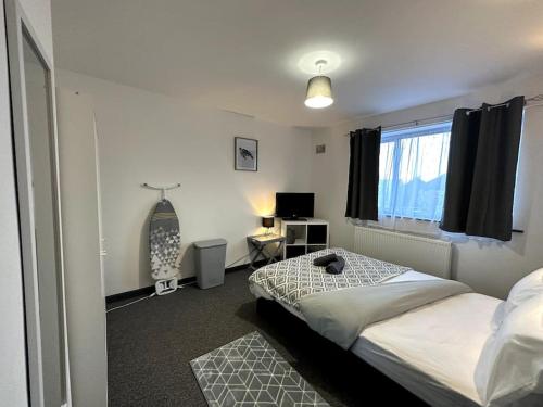 a bedroom with a bed and a desk and a window at Wigan Haven Modern & Relaxing in Pemberton